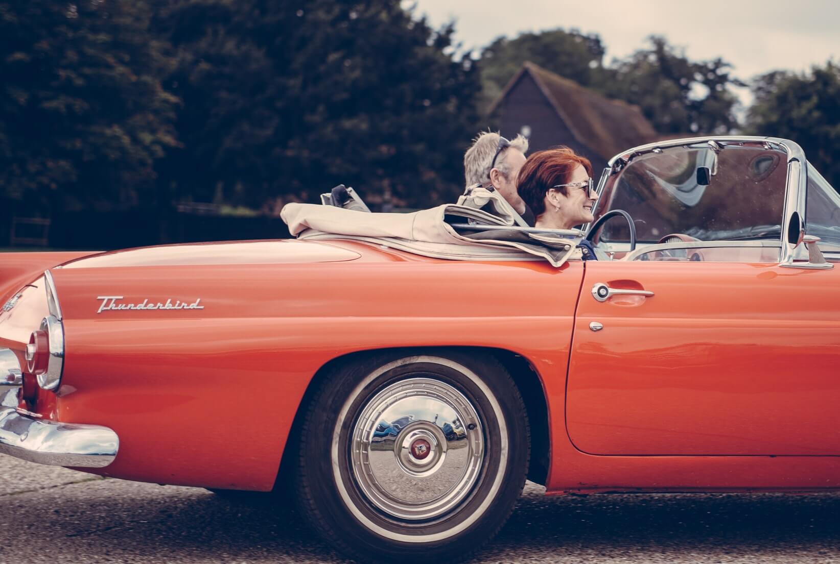 Man and woman ride orange car 
