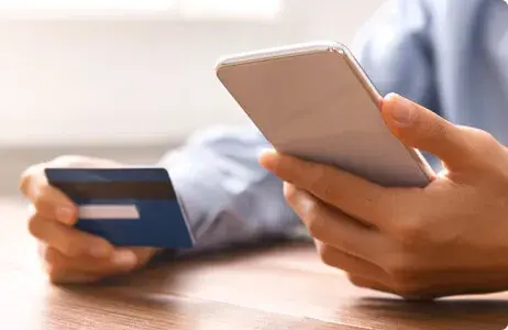 Person holding phone and credit card 