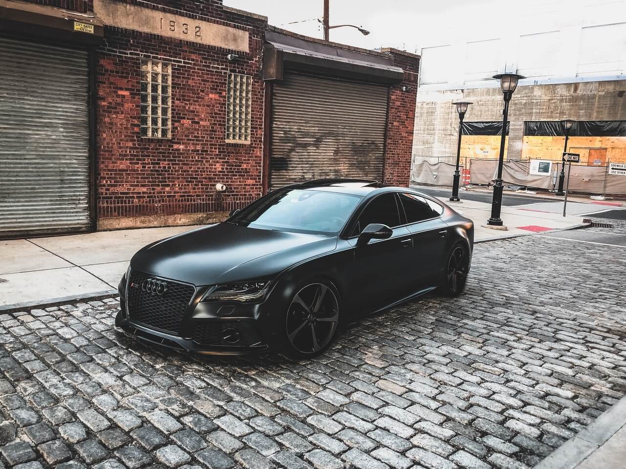 Black matte Audi in front of garages 