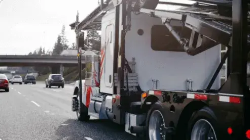 White Semitruck Transporting Cars on Highway White Semitruck Transporting Cars on Highway